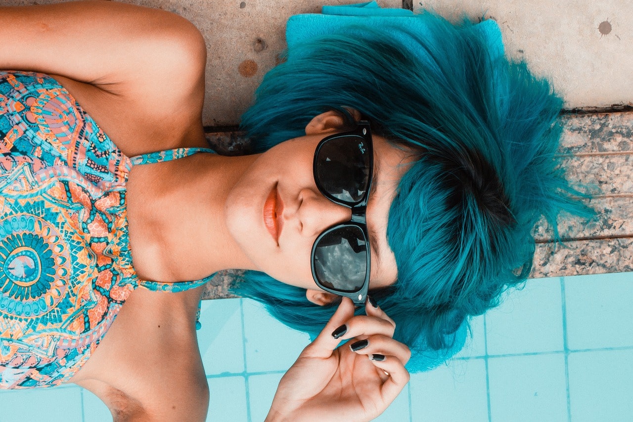 Ragazza distesa che indossa maxo accessori ed abito tonalità pastello trendi per la primavera estate 2025