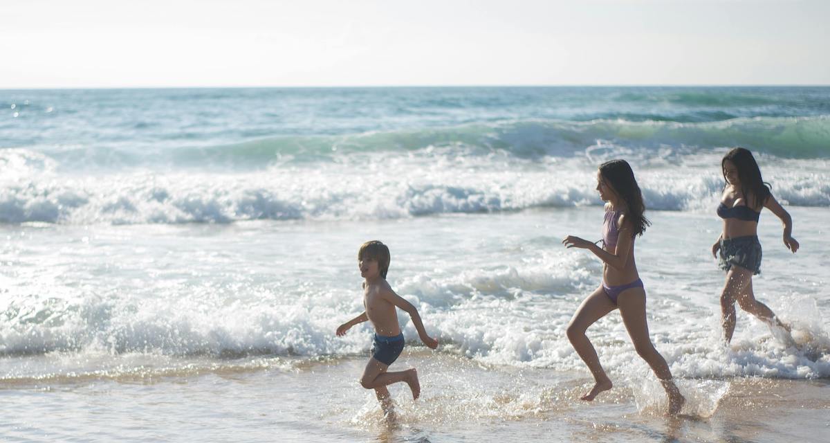 bambini che corrono sulla spiaggia al mare durante una vacanza no stress